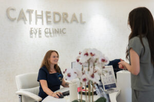 A young woman with dark hair checking into a laser eye surgery belfast appointment.